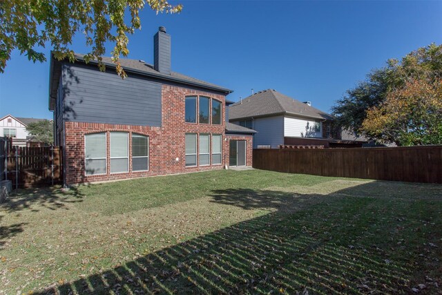 back of house with a lawn