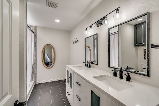 bathroom featuring vanity, toilet, and tile patterned flooring