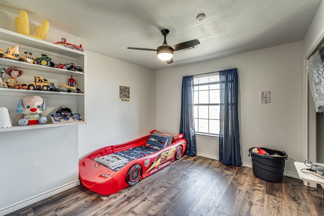 bedroom featuring a textured ceiling, dark hardwood / wood-style floors, and ceiling fan