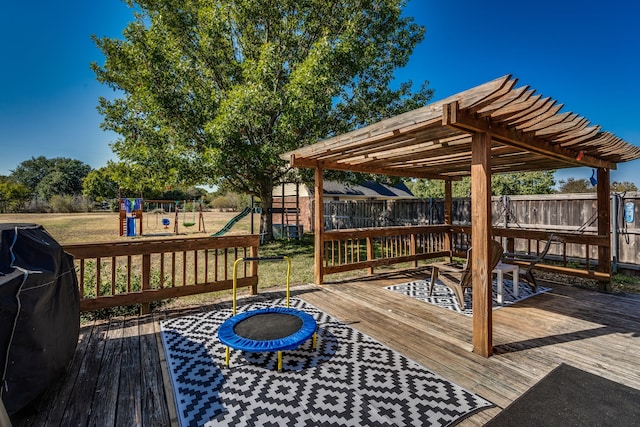 wooden deck with a playground, a pergola, and area for grilling