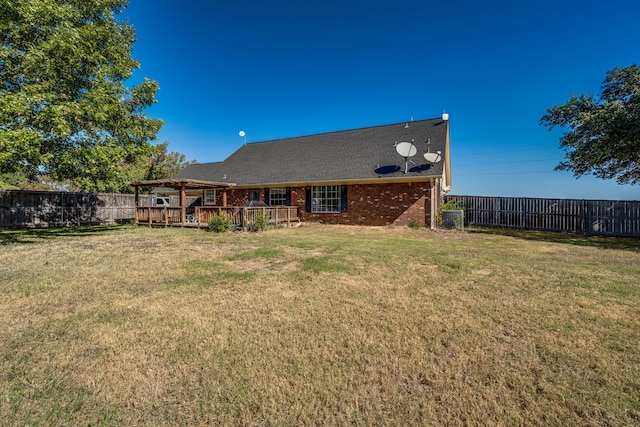 rear view of property with a deck and a lawn