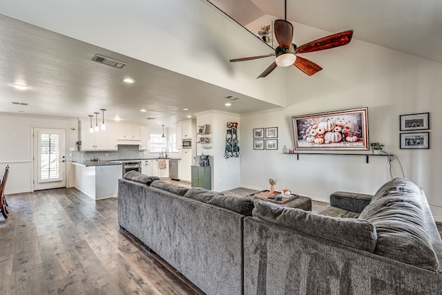 living room featuring ceiling fan, dark hardwood / wood-style flooring, crown molding, and lofted ceiling