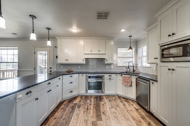 kitchen with white cabinetry, decorative light fixtures, and stainless steel appliances