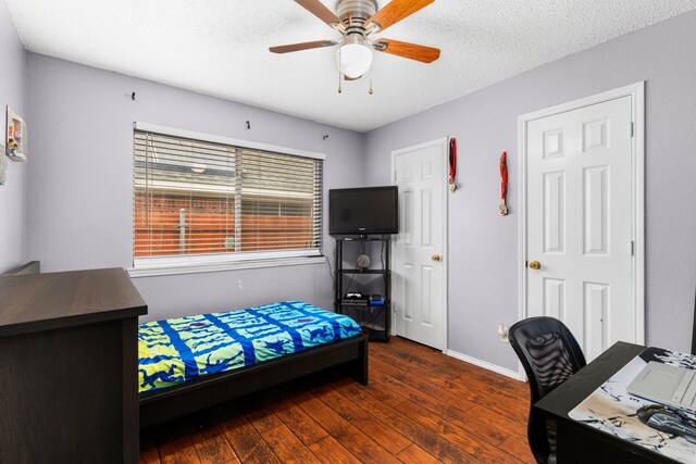 bedroom featuring a textured ceiling, dark hardwood / wood-style floors, and ceiling fan