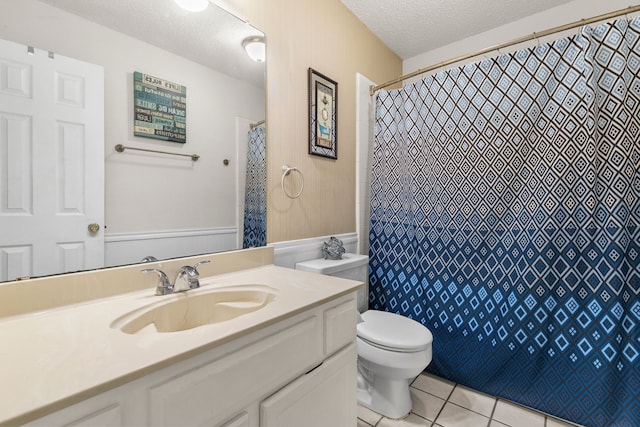 bathroom featuring tile patterned flooring, vanity, a textured ceiling, and toilet