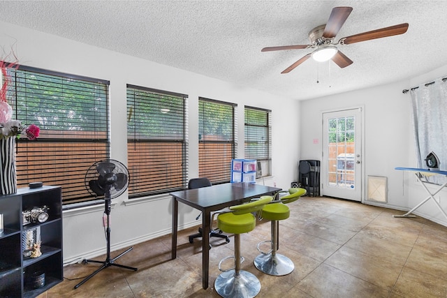 tiled office space with ceiling fan and a textured ceiling