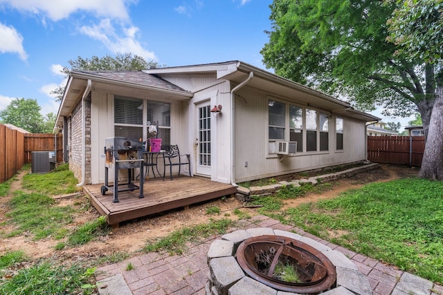 rear view of property featuring a fire pit, central AC unit, cooling unit, and a wooden deck