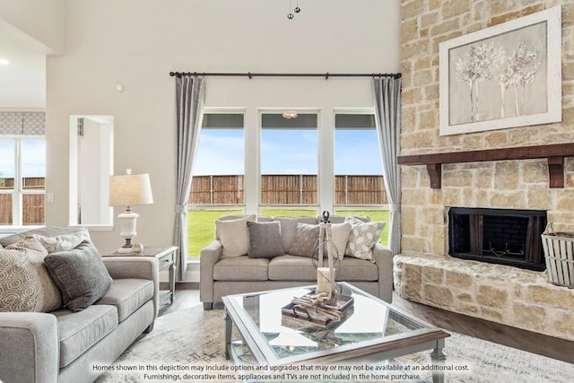 living room with a wealth of natural light, a fireplace, and hardwood / wood-style flooring