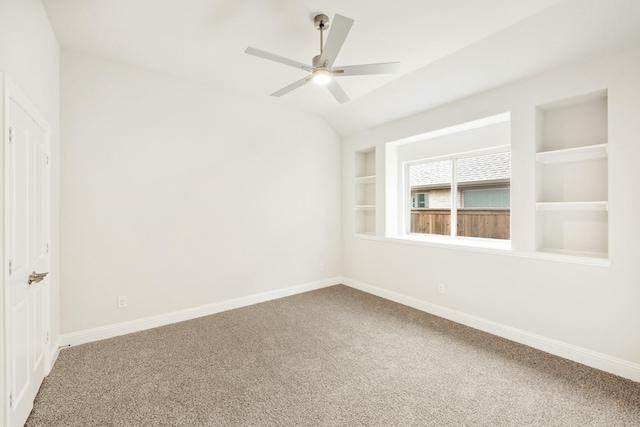 carpeted spare room with baseboards, ceiling fan, lofted ceiling, and built in features