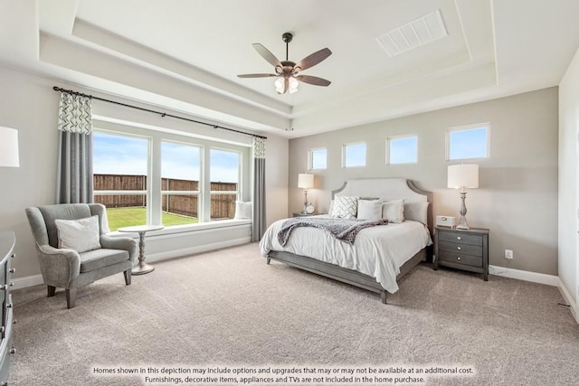 bedroom featuring ceiling fan, a raised ceiling, and carpet floors