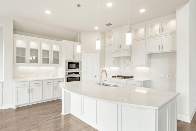 kitchen featuring stainless steel appliances, white cabinets, light countertops, and a sink