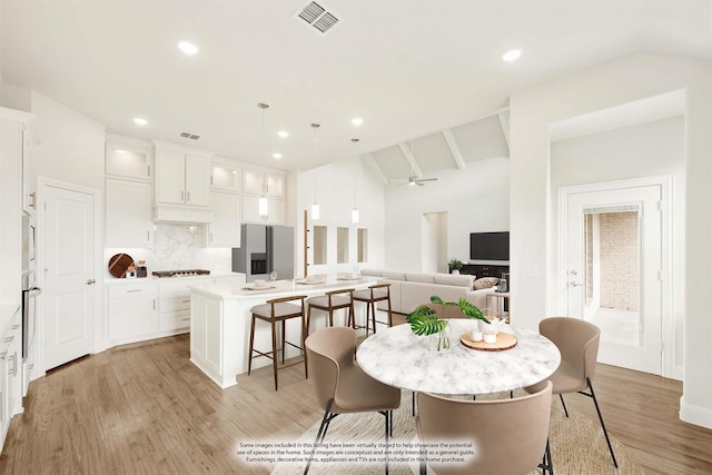 dining space featuring visible vents, lofted ceiling, ceiling fan, light wood-style floors, and recessed lighting