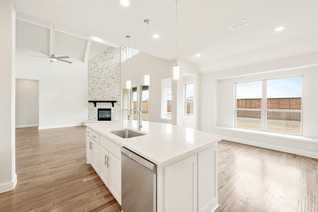 kitchen featuring a sink, visible vents, white cabinetry, open floor plan, and dishwasher