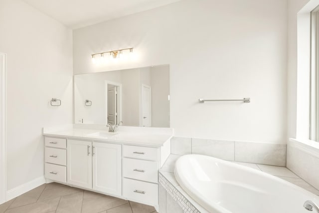 full bath with tile patterned floors, baseboards, a bath, and vanity