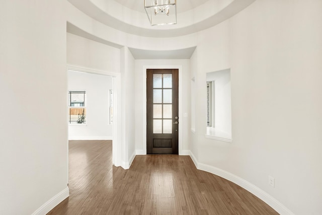 entrance foyer featuring an inviting chandelier, baseboards, and wood finished floors