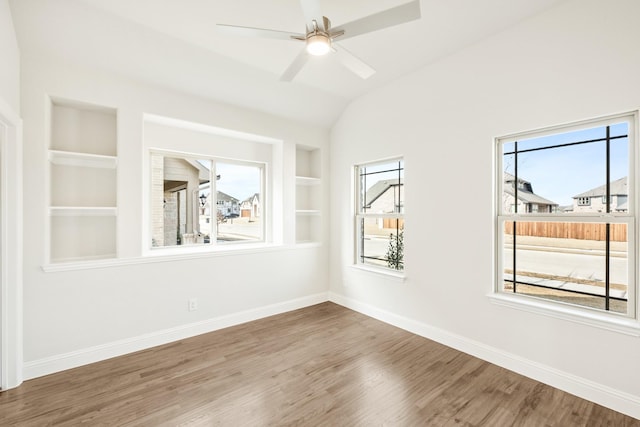 empty room with baseboards, a healthy amount of sunlight, and built in features