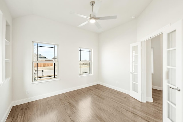 empty room featuring lofted ceiling, french doors, baseboards, and light wood-style floors