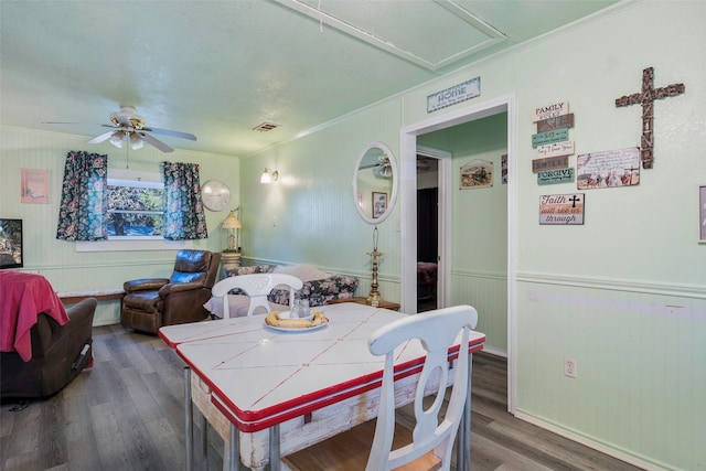 dining room featuring ceiling fan, dark wood-type flooring, a textured ceiling, and ornamental molding