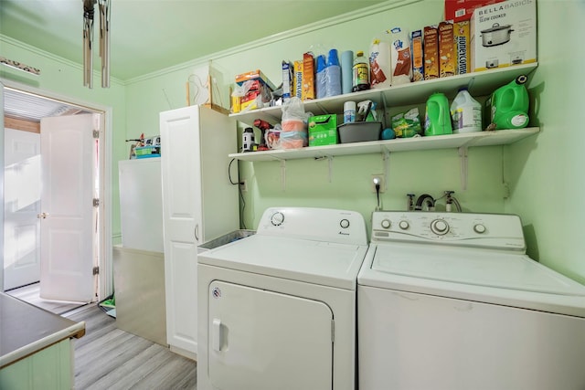 laundry room featuring independent washer and dryer, ornamental molding, and light hardwood / wood-style flooring