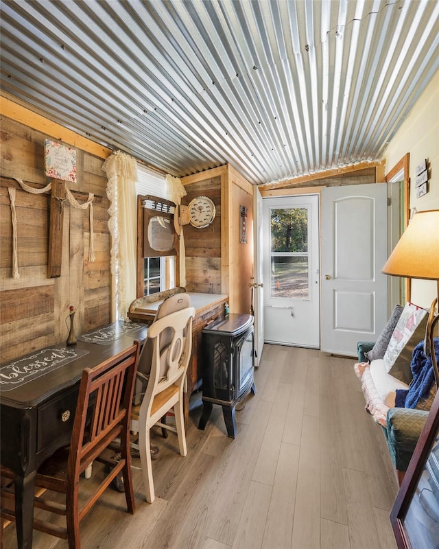 office with a wood stove, wooden walls, and light wood-type flooring