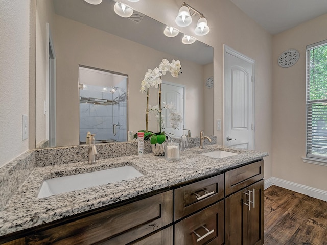 bathroom with hardwood / wood-style flooring, vanity, and an enclosed shower