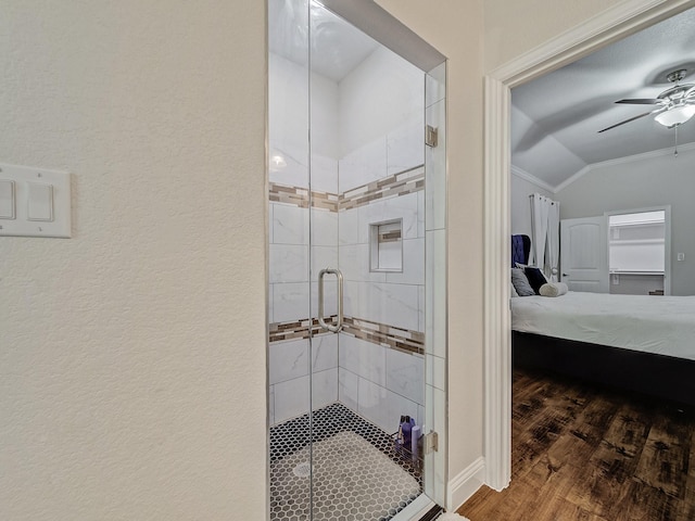 bathroom featuring lofted ceiling, ornamental molding, a shower with door, and wood-type flooring