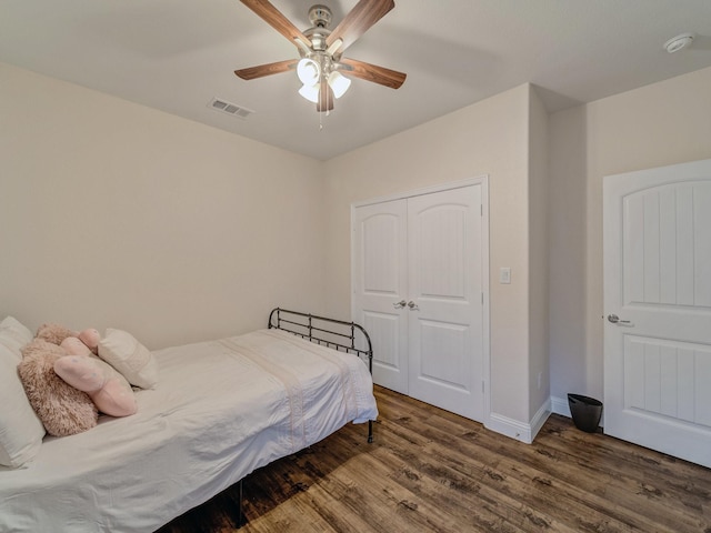 bedroom with a closet, dark hardwood / wood-style floors, and ceiling fan