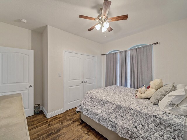 bedroom with dark hardwood / wood-style flooring, a closet, and ceiling fan