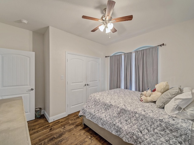 bedroom with dark hardwood / wood-style floors, ceiling fan, and a closet