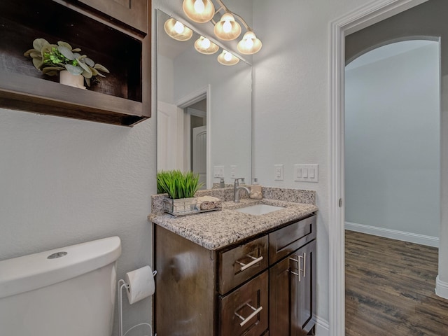 bathroom with toilet, vanity, and hardwood / wood-style flooring