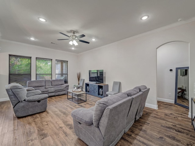 living room with hardwood / wood-style flooring, ceiling fan, and crown molding