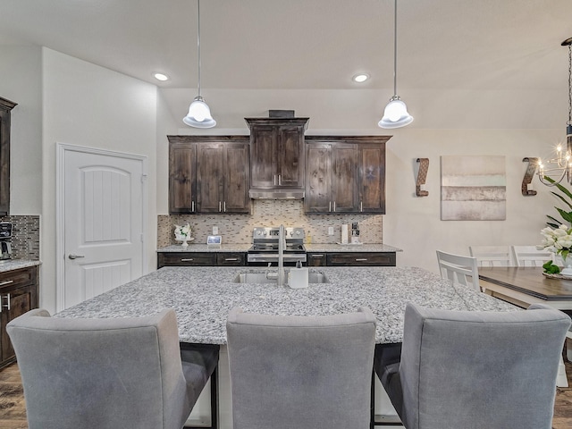 kitchen featuring dark brown cabinets, hanging light fixtures, and electric range