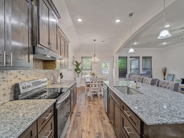 kitchen featuring pendant lighting, sink, an island with sink, wood-type flooring, and stainless steel appliances