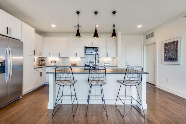 kitchen featuring appliances with stainless steel finishes, dark hardwood / wood-style floors, white cabinetry, and hanging light fixtures