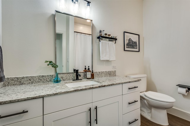 bathroom with walk in shower, vanity, wood-type flooring, and toilet