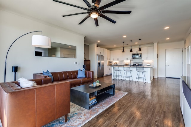 living room with hardwood / wood-style floors, ceiling fan, and crown molding