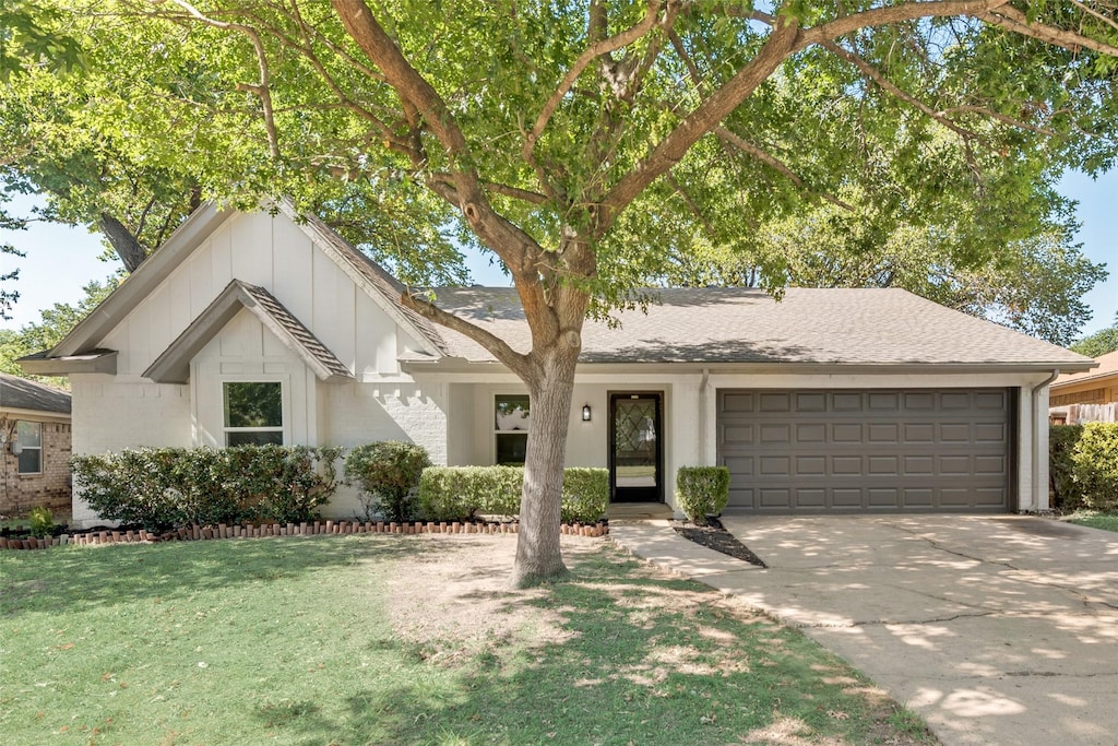 view of front of home with a garage and a front lawn