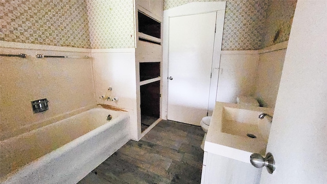 bathroom with vanity, hardwood / wood-style floors, a bathtub, and toilet