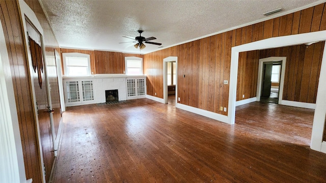 unfurnished living room with ceiling fan, dark hardwood / wood-style floors, a textured ceiling, and a fireplace