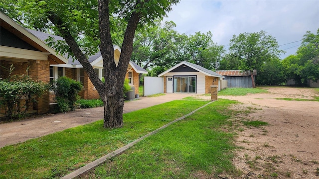 view of front of home with an outdoor structure and a front lawn