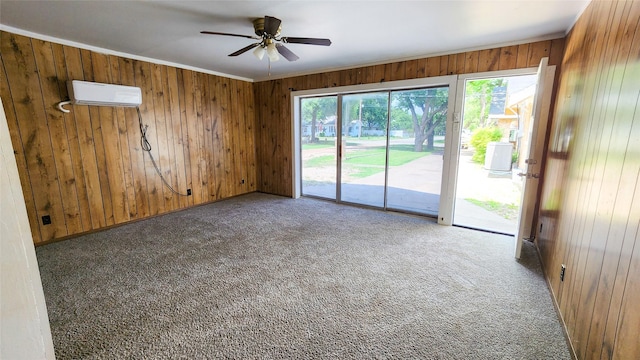 carpeted spare room featuring ceiling fan, ornamental molding, a wall mounted AC, and wood walls