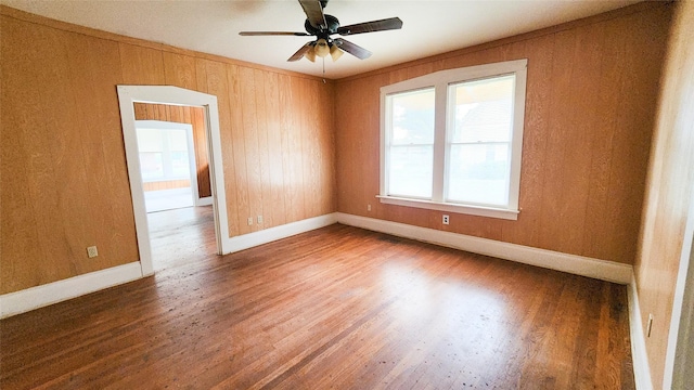 unfurnished room featuring wood-type flooring, ornamental molding, and ceiling fan