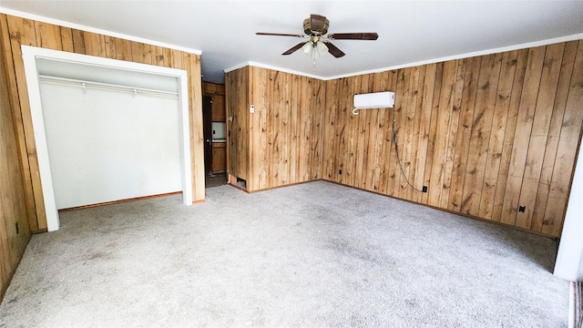 unfurnished bedroom featuring wooden walls, a wall mounted AC, ornamental molding, light colored carpet, and a closet