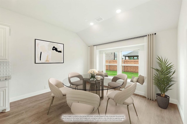 dining room with light hardwood / wood-style floors and lofted ceiling