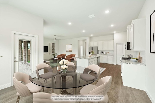 dining space with ceiling fan and hardwood / wood-style floors