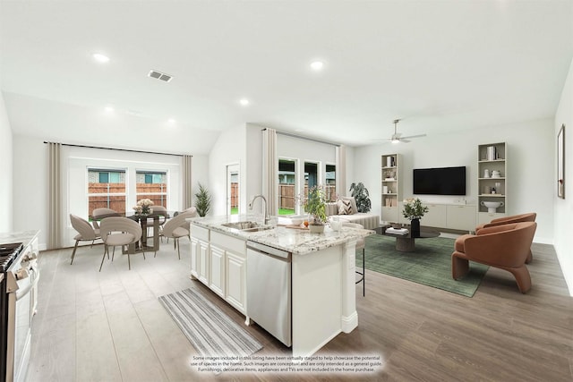 kitchen with a kitchen island with sink, sink, light wood-type flooring, white cabinetry, and stainless steel appliances