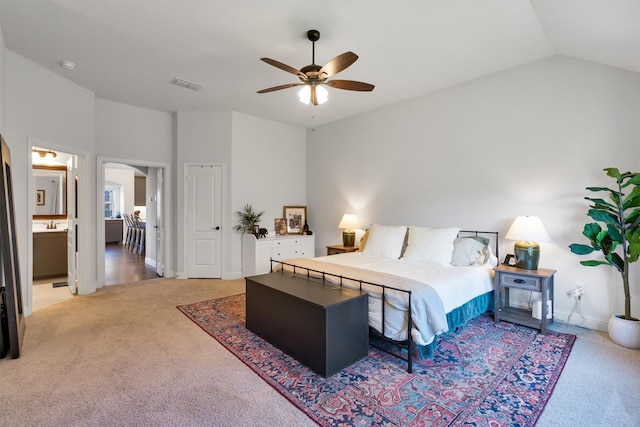 bedroom featuring light carpet, ensuite bath, ceiling fan, and lofted ceiling