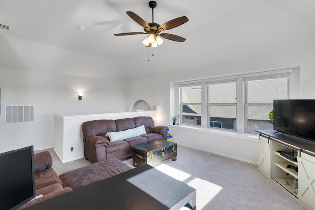 carpeted living room with ceiling fan and vaulted ceiling