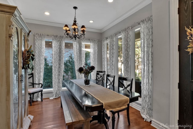 dining space with dark wood-type flooring, crown molding, and a chandelier