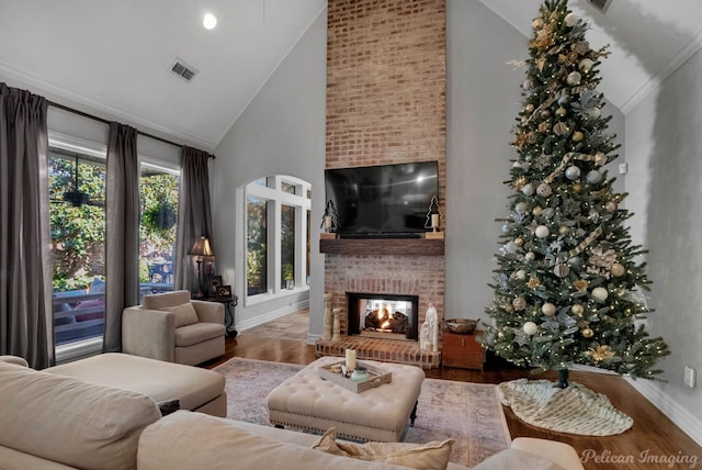 living room with ornamental molding, hardwood / wood-style floors, a fireplace, and high vaulted ceiling